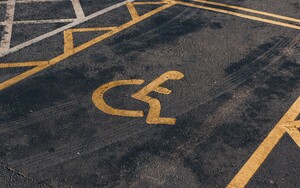 A handicap parking space with a yellow wheelchair symbol