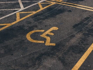 A handicap parking space with a yellow wheelchair symbol